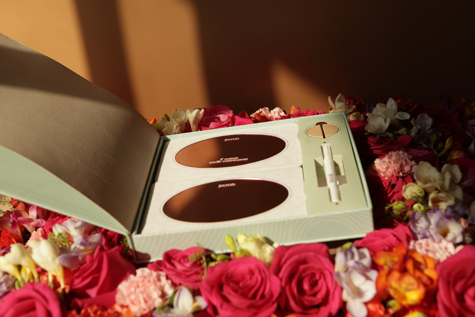 Prosperity Ritual Kit with rose gold glass mirror reflection cards, artisan incense paper, marker and recyled bamboo stand on bed of roses. mirror work, affirmation cards.