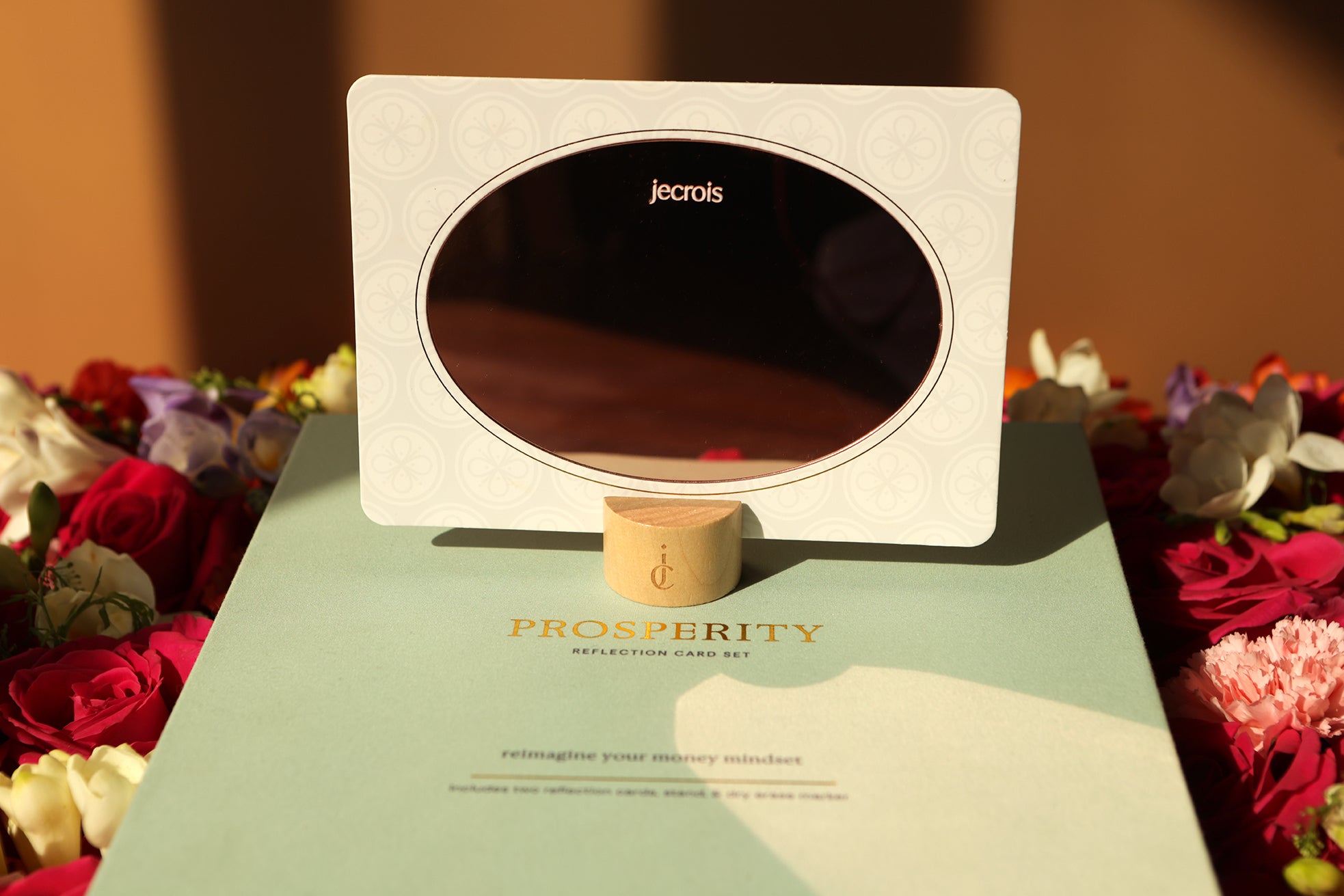 Prosperity Ritual Kit with affirmation card reflection card and bamboo stand displayed on box, surrounded by red roses